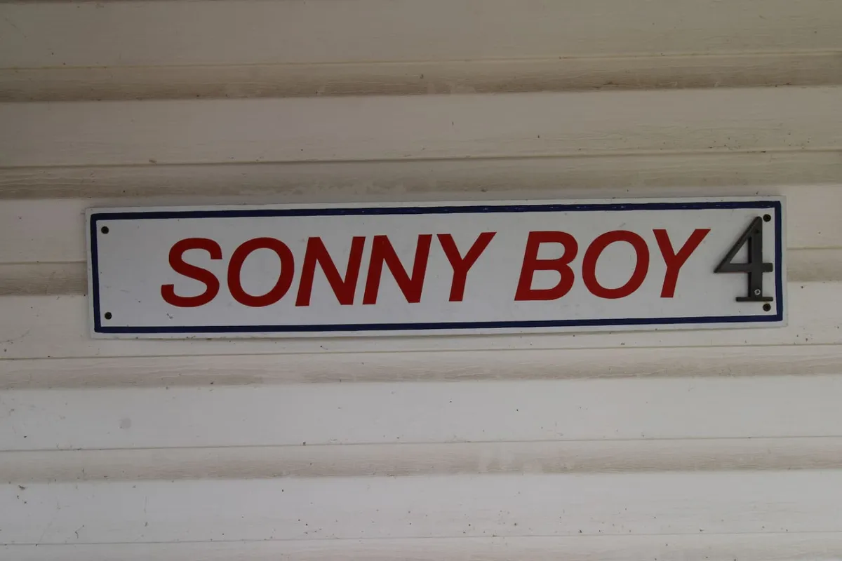 A rustic interior with wood detailing and a nostalgic sign reading 'SONNY BOY 4.' The decor evokes a sense of warmth and history, adding personality and charm to the living space.